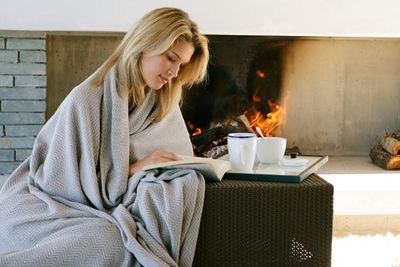 девушка в пледе читает книгу