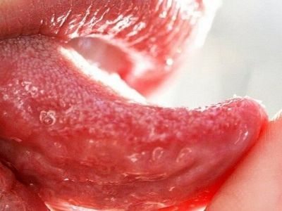 Женщина трогает язык пальцем